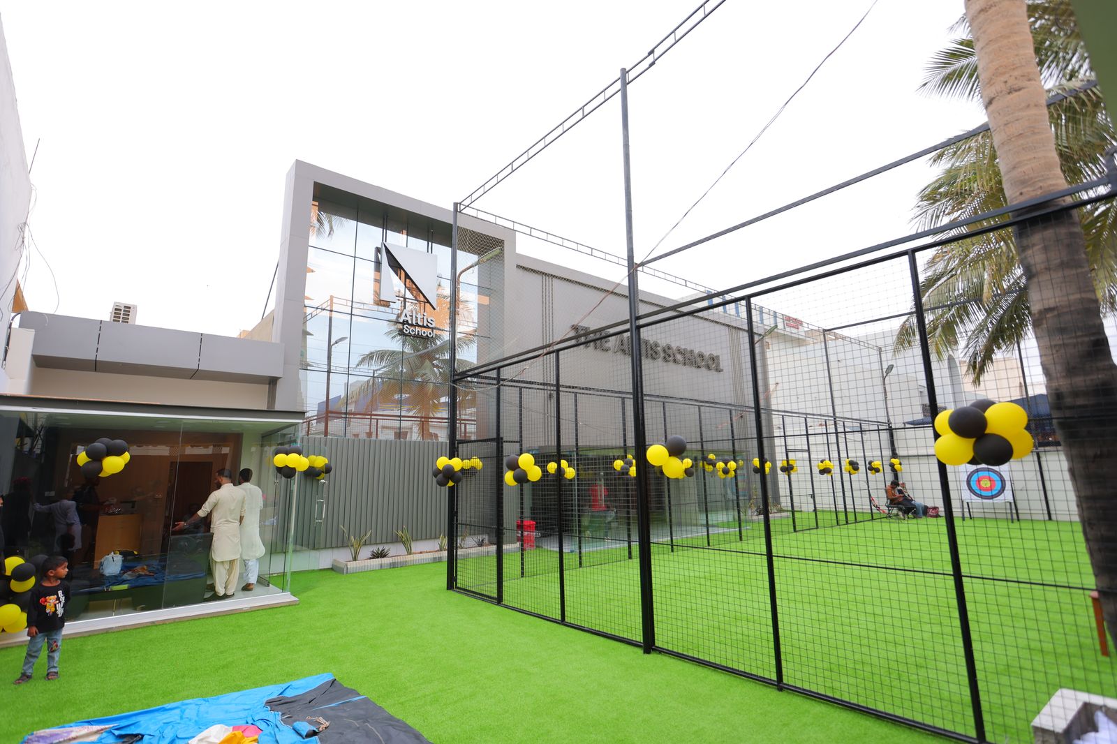 Wide view of Altis School campus with sports court and building signage